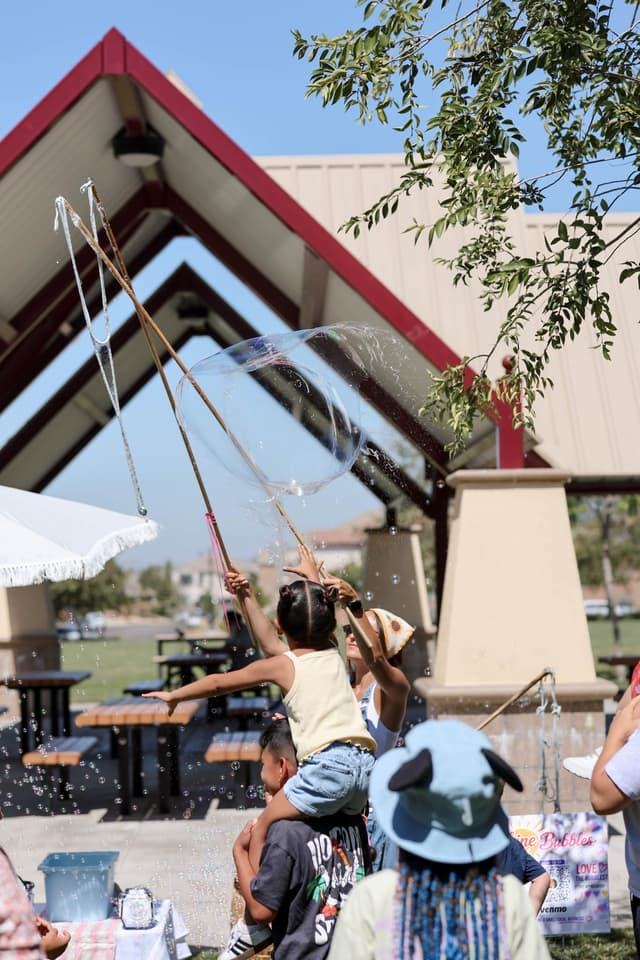 Child reaching for a giant bubble