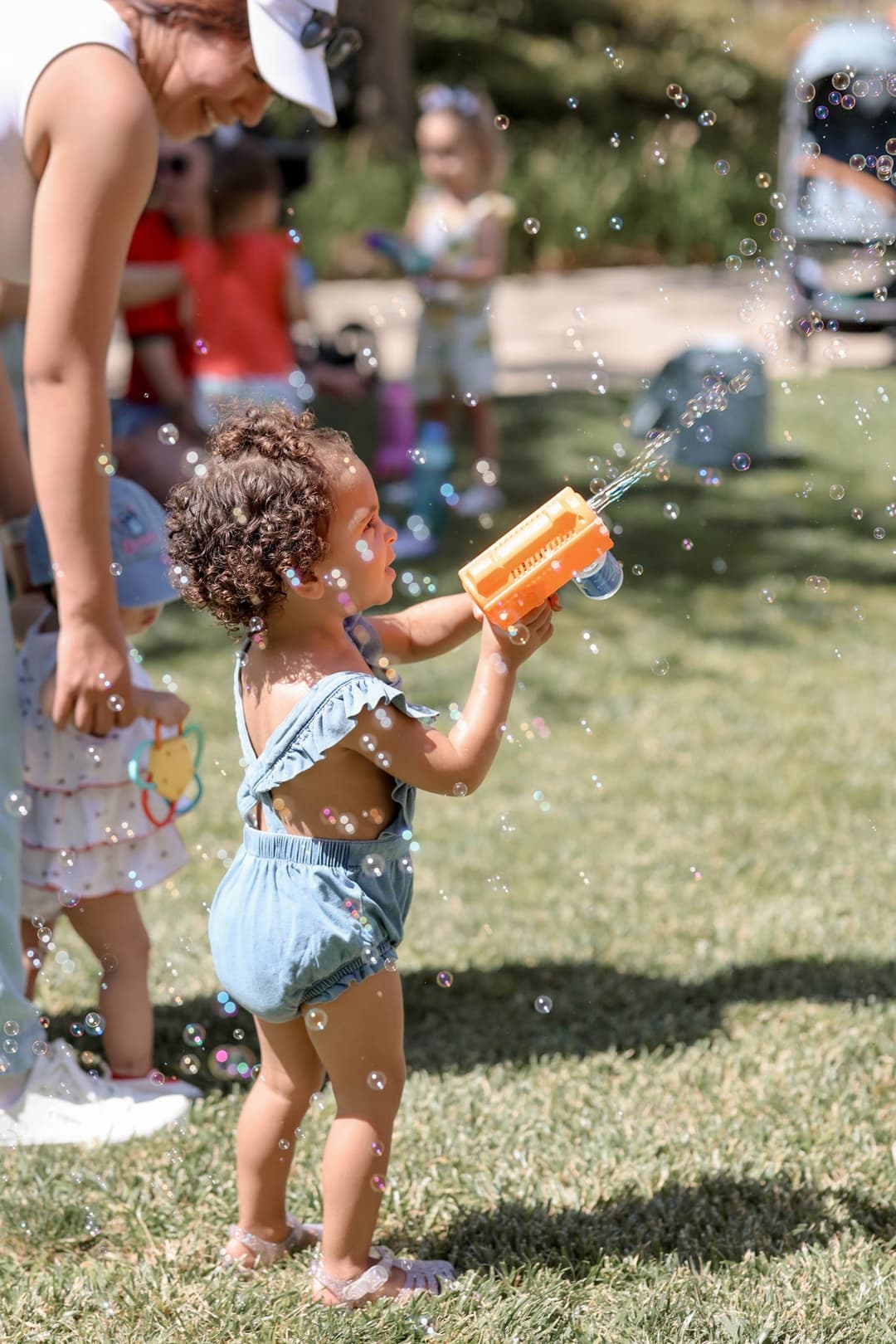 Toddler playing with a bubble gun